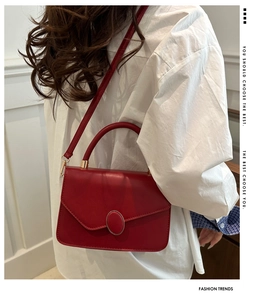 Dettaglio della borsa rossa in pelle PU con fibbia magnetica ovale e tracolla