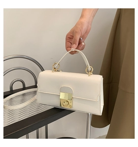 Macro shot of white leather handbag featuring premium gold square buckle and fixed handle