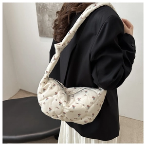 Detailed view of quilted floral canvas bag with knotted strap and metal zipper