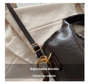 Detail shot of deep brown leather bag showing adjustable gold buckle and stitching