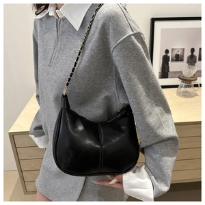 Detail of minimalist black hobo bag with chain strap and elegant stitched finish