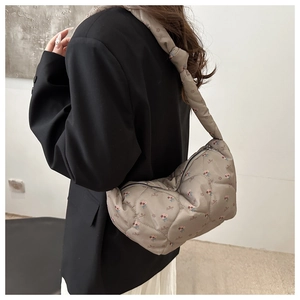 Détails du matelassage en cœur et de l'imprimé fleuri sur le grand sac en nylon
