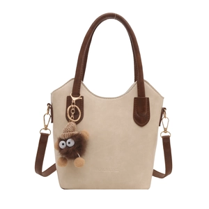 Retro cream and brown bucket bag with a cute plush charm and adjustable strap
