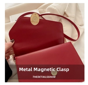 Dettaglio della chiusura magnetica dorata sulla borsa a tracolla in pelle rossa
