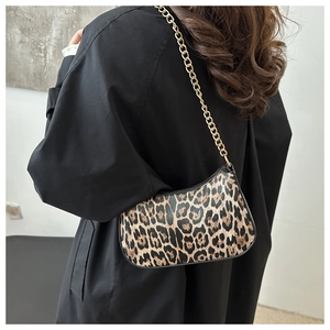 Detail of leopard print crescent bag featuring gold chain strap and vintage crescent design