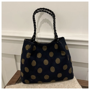 Détail du sac cabas en laine bleu marine à gros pois olive et poignées en cuir tressé noir