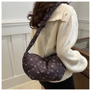 Detailed close-up of quilted floral print nylon hobo bag on shoulder for daily use