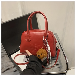 Red Boston bag with Louky embossing, featuring a plush puppy charm and detachable strap