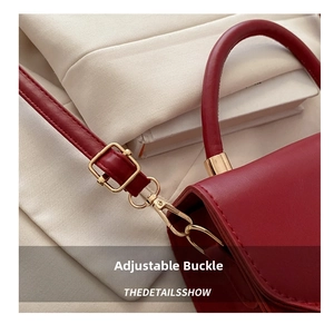 Dettaglio della borsa in pelle rossa con fibbie in metallo dorato e cuciture