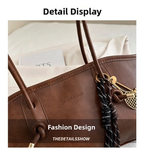 Détail d'un sac cabas marron avec texture en cuir et un pendentif raquette de tennis doré