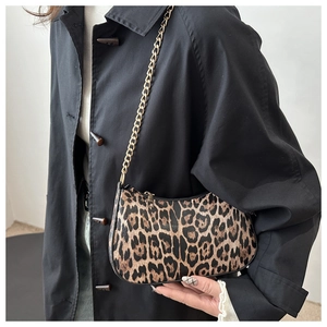 Detail of trendy leopard print crescent bag featuring a gold chain and zipper closure