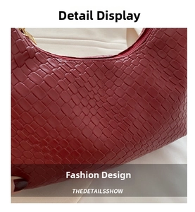 Close-up of red crocodile embossed leather texture with golden metal zipper detail