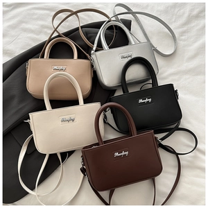 Top view of compact crossbody square bags in five colors on a textured background