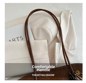 Détail de la poignée confortable d'un grand sac cabas en cuir marron foncé pour femme