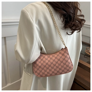 Detailed view of pink crescent bag with monogram print and golden chain strap