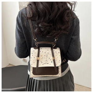 Close-up of color-block polka dot backpack with Aimity 1986 rabbit logo and metal buckle