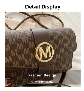 Close-up of the brown leather monogram M pattern bag with golden metallic M magnetic buckle