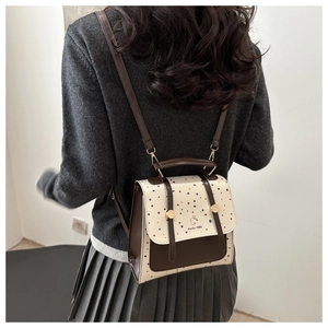 Close-up of small vintage backpack with colorful heart patterns and metal ring strap