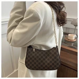 Close-up of brown monogram pattern shoulder bag with elegant gold chain and zipper