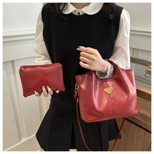 Burgundy tote bag and clutch set featuring high-gloss leather and gold accents