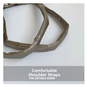 Detail of padded quilted shoulder strap on a bronze metallic puffy tote bag