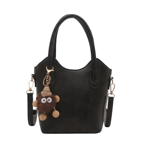 Retro black faux leather bucket handbag with plush monster charm and detachable strap