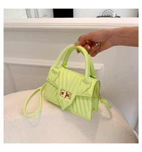 Detailansicht der neongrünen Stepptasche mit goldenem Drehverschluss und Schultergurt
