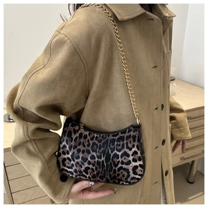 Detail of trendy leopard print baguette bag featuring golden chain strap and leather texture