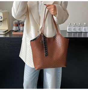 Close-up of brown woven texture leather tote bag with stylish dark tassel ornament