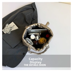 Spacious interior of a metallic quilted tote bag holding a tablet, umbrella, and bottle