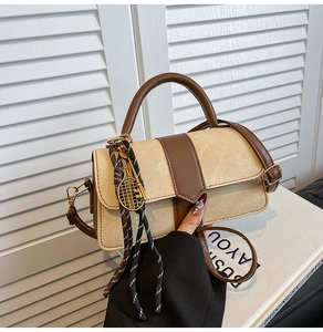 Detail of vintage beige crossbody bag with brown trim and tennis racket charm