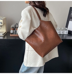 Detailed close-up of brown faux-crocodile texture on a large capacity tote bag