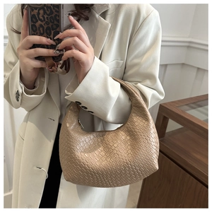 Detail of hand-woven beige hobo bag with high-quality leather texture and zipper closure