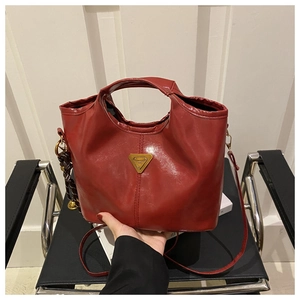 Close-up of wine red oil wax leather tote bag with iconic golden triangle metal logo