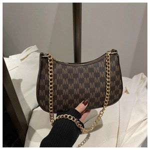Detail of vintage brown monogram handbag featuring gold chain strap and M-pattern texture