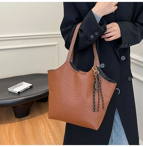 Brown woven texture tote bag with large capacity held by a model in a minimal setting