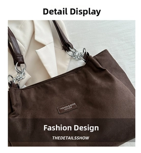 Dettaglio della borsa tote in pelle scamosciata marrone con catena argento e logo