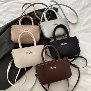 Chic multi-color crossbody bucket bags set in beige, black, and brown with metal logos