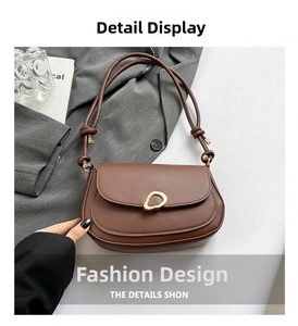Close-up of brown saddle bag with golden irregular ring metal buckle and matte leather texture