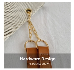 Detail of polished golden chain and brown leather strap with fine stitching on tote bag