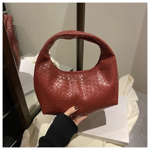 Close-up of brick red woven leather hobo bag featuring intricate checkerboard texture