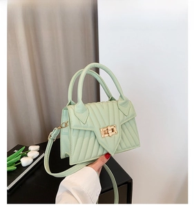 Detailansicht der hellgrünen kleinen Tasche mit V-Steppung und goldenem Drehverschluss