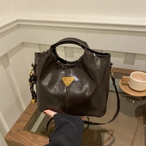 Vintage caramel oil wax leather bucket bag with top handle and gold emblem detail