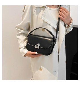 Close-up of black retro shoulder bag with silver heart-shaped metal twist lock detail