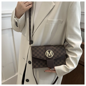 Close-up of brown crossbody bag with M-letter print and gold circular metal buckle