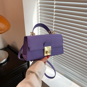 Elegant lavender purple shoulder bag with gold clasp shown in a lifestyle home setting
