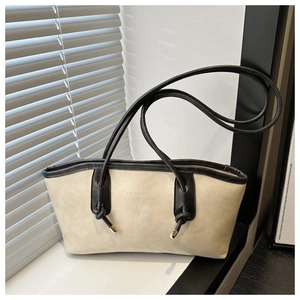 Détail d'un cabas beige avec bordure noire et lettrage FASHION & BAGS près d'une fenêtre