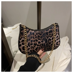Detailed close-up of leopard print crescent bag featuring a chunky gold metal chain strap