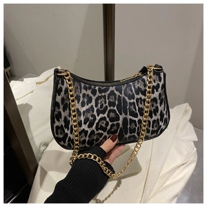 Detail of leopard print crescent bag with chunky gold chain strap and zipper closure