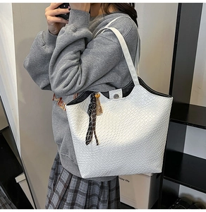 Detailed shot of white tote bag with woven texture and decorative silk scarf on shoulder